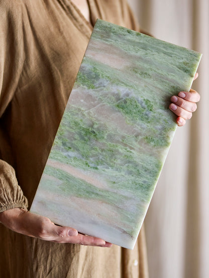 Žalia marmuro pjaustymo lenta „Keika“, laikoma rankose, natūralus akmens raštas 