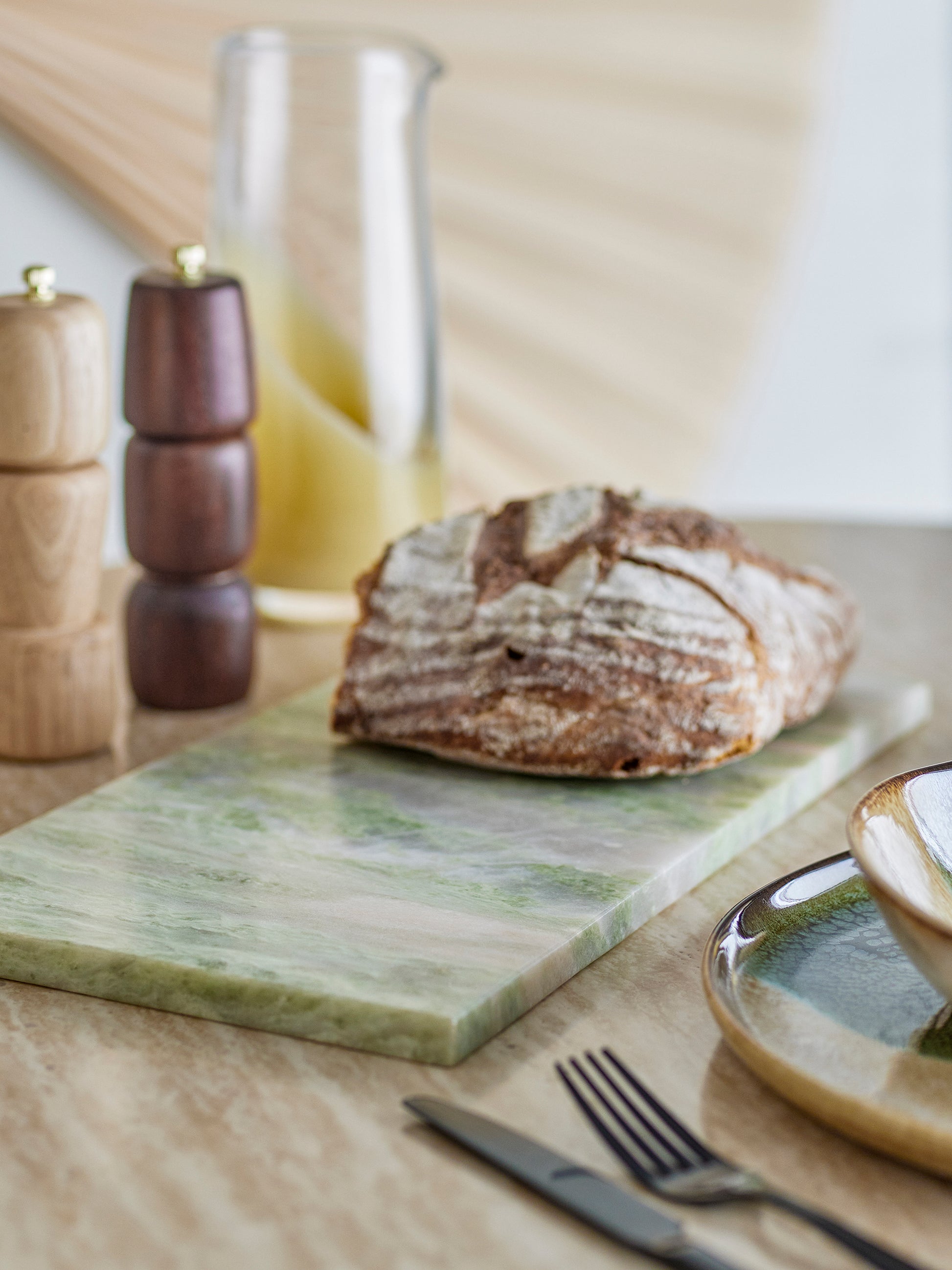 Žalia marmuro pjaustymo lenta „Keika“ virtuvėje, naudojama kaip serviravimo lenta duonai.